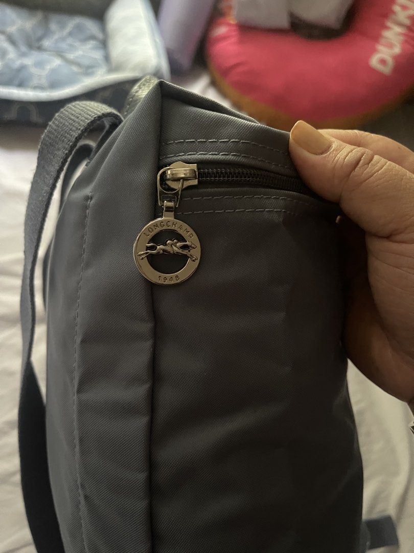 PRELOVED Longchamp Le Pliage Backpack BLUE GREY (Category: Backpacks) located in Pasay City. Submitted by epictiger.84b83d (Listing ID 1447489366, Image 2). Description: - Authentic Grey Longchamp Le Pliage Backpack - Durable Nylon Material with Leather Trim - Iconic Horse Logo Detail - Secure Zipper Closure with Snap Button Flap - Adjustable Shoulder Straps - Ideal for Everyday Use or Travel.