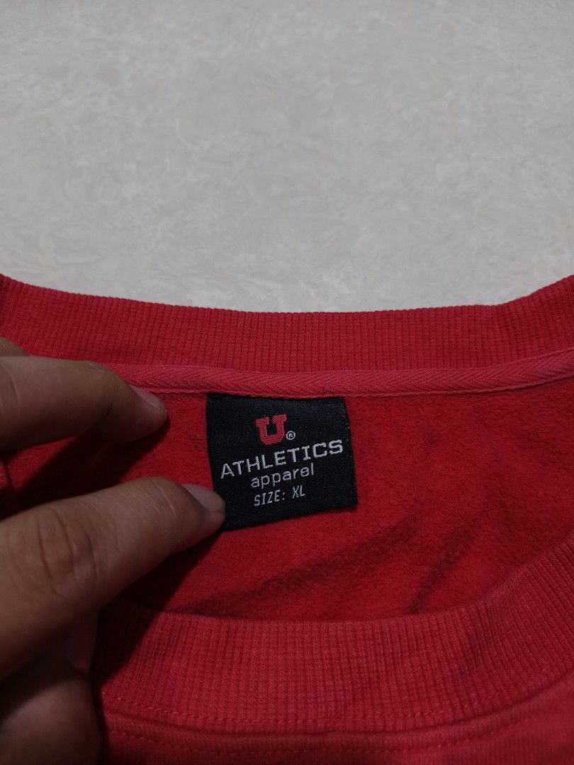 Red U Athletics Sweatshirt Size XL (Category: Coats, Jackets and Outerwear) located in Quezon City. Submitted by jamtnf (Listing ID 1447643221, Image 2). Description: - Red U Athletics sweatshirt - Size XL - 'U Athletics' graphic on the front - Pac-12 logo patch on the left sleeve - Ideal for casual wear or sports enthusiasts.