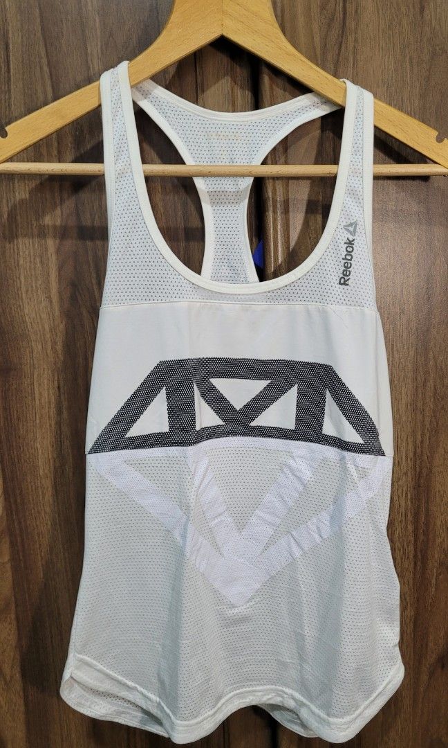 Reebok Diamond Graphic Tank Top White (Category: Activewear) located in Davao. Submitted by NearlyNew (Listing ID 1447511684, Image 2). Description: - White Reebok tank top - Grey diamond graphic across chest - Lightweight and breathable fabric - Racerback design - Ideal for workouts or casual styling.