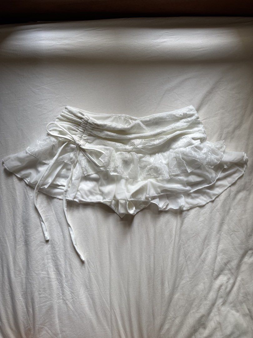 SHEIN White Lace Ruffle Drawstring Mini Skirt (Category: Skirts) located in Petaling Jaya. Submitted by mellowmarket (Listing ID 1447540932, Image 1). Description: - White mini skirt from SHEIN - Features a delicate lace overlay - Ruffled trim for a feminine touch - Adjustable drawstring waist - Built-in shorts for comfort and coverage - Perfect for a fun and flirty look.