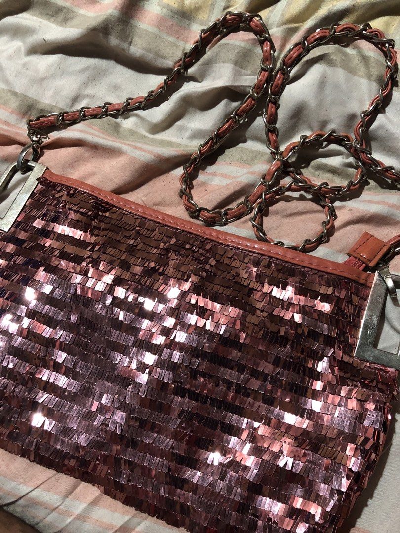 Sparkly Rose Gold Shoulder Bag with Chain Strap (Category: Shoulder Bags) located in Manila. Submitted by bakithrift213 (Listing ID 1447630235, Image 2). Description: - Cute sparkly rose gold shoulder bag - Features a chain strap with faux leather detail - Quilted faux leather material on the back - Secure zipper closure - Ideal for nights out or adding glam to any outfit - Approximate dimensions: 9 inches wide x 5 inches tall.