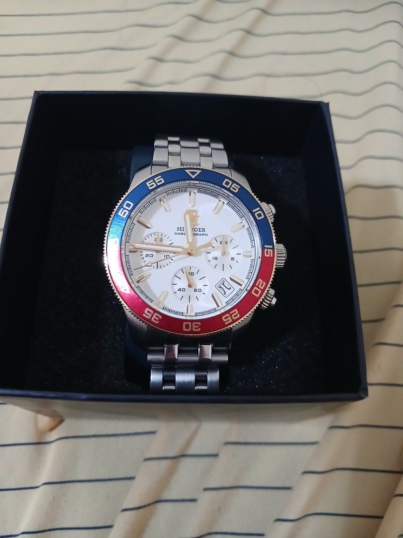 Tommy Hilfiger Chronograph Watch (Category: Men's Watches) located in Quezon City. Submitted by vanlacsa (Listing ID 1447642324, Image 2). Description: - Authentic Tommy Hilfiger Chronograph Watch - Elegant White Dial with Gold Accents - Distinctive Red and Blue Bezel - Durable Stainless Steel Band - Comes with Original Box and Manual - Versatile: Ideal for Everyday or Special Occasions - A Timeless Classic bought last May 2026 16k orig price rfs