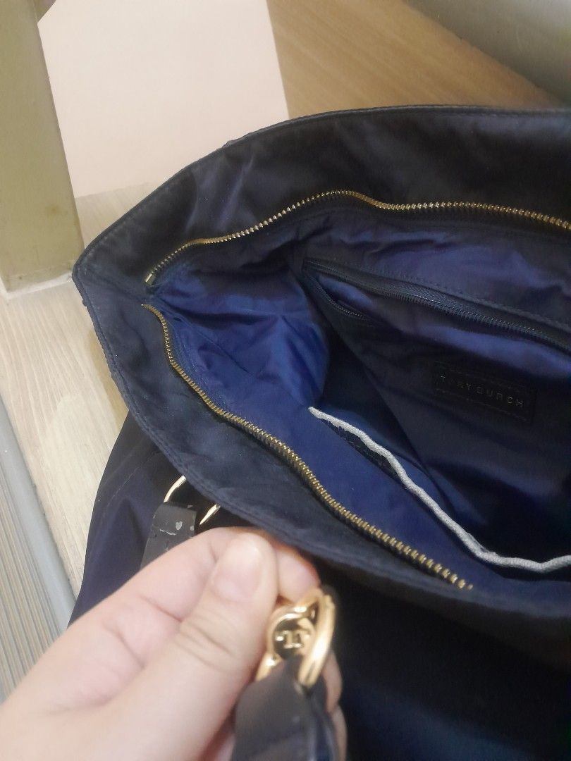 Tory Burch Navy Nylon Tote Bag (Category: Shoulder Bags) located in Angeles City. Submitted by declutterhub (Listing ID 1447494320, Image 3). Description: Navy blue Tory Burch nylon tote bag with leather handles. Features gold hardware, an interior zip pocket, and a slip pocket. Spacious and perfect for daily use..