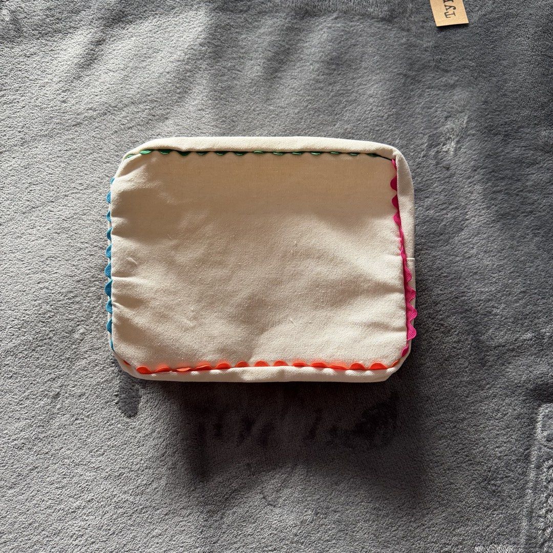 Unbranded Pouch with Colorful Detailing (Category: Purses & Pouches) located in Pasig City. Submitted by swag.maxxing (Listing ID 1447538936, Image 1). Description: - Unbranded pouch with vibrant, colorful stitching detail. - Made from durable canvas material. - Features a clean, lined interior for added protection. - Perfect for organizing makeup, stationery, or small essentials. - Versatile and stylish accessory..