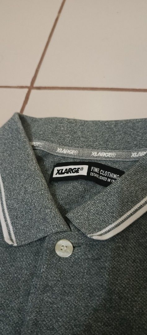 XLARGE® 91 Graphic Polo Shirt Grey (Category: Tshirts & Polo Shirts ) located in Santa Cruz. Submitted by jm.stuffs (Listing ID 1447636780, Image 3). Description: - XLARGE® Polo Shirt in XL size. - Features iconic XLARGE® logo on the front. - '91' graphic detail on the sleeve. - Stylish striped collar and sleeve cuffs. - Small red XLARGE® trademark tag on the hem. - Perfect for a cool, casual look..