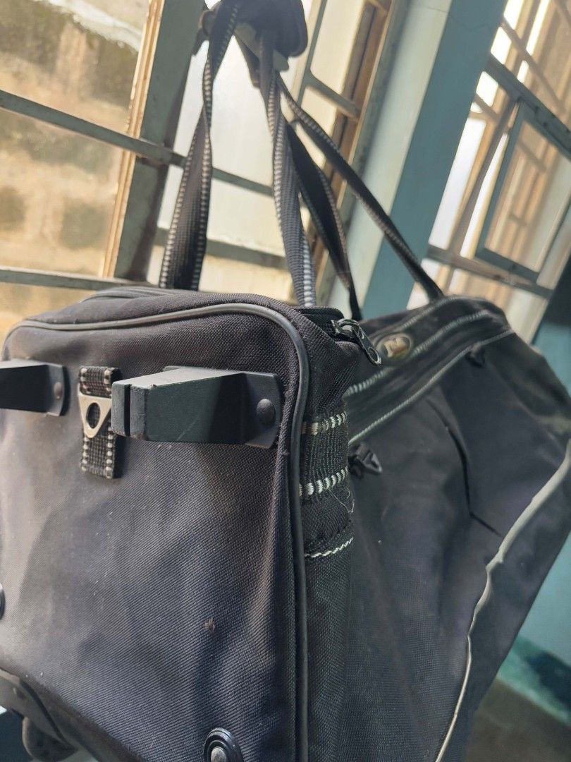Black Duffle Bag with Wheels (Category: Luxury Bags & Wallets) located in Quezon City. Submitted by giveitalife (Listing ID 1447882389, Image 3). Description: - Black duffle bag - Features handles and wheels for easy transport - Ample interior space for all your essentials - Zippers are in good working condition - Shows minor scuffing on the bottom from normal use - Ideal for weekend getaways or overnight stay.