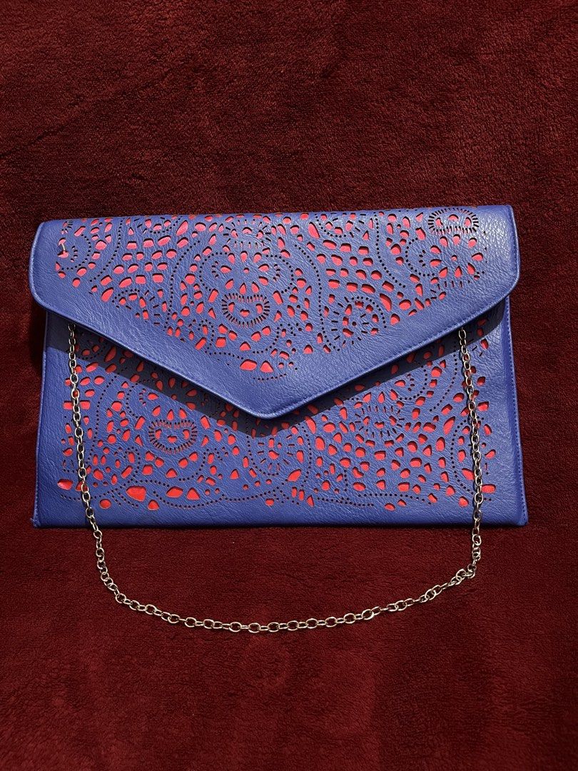 Blue Laser Cut Clutch Bag with Chain (Category: Clutches) located in La Trinidad. Submitted by whatnotcollections (Listing ID 1447811564, Image 2). Description: - Eye-catching blue laser-cut design with bold bright pink combination. - Detachable silver chain shoulder strap. - Secure magnetic snap closure - Ideal for evening wear and special occasions - Dimensions: Approximately 12.5 inches wide by 8.25 inches tall Slightly negotiable for sure buy