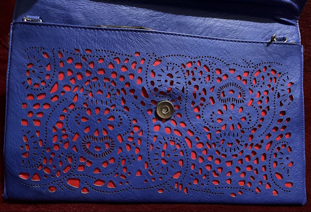 Blue Laser Cut Clutch Bag with Chain (Category: Clutches) located in La Trinidad. Submitted by whatnotcollections (Listing ID 1447811564, Image 3). Description: - Eye-catching blue laser-cut design with bold bright pink combination. - Detachable silver chain shoulder strap. - Secure magnetic snap closure - Ideal for evening wear and special occasions - Dimensions: Approximately 12.5 inches wide by 8.25 inches tall Slightly negotiable for sure buy