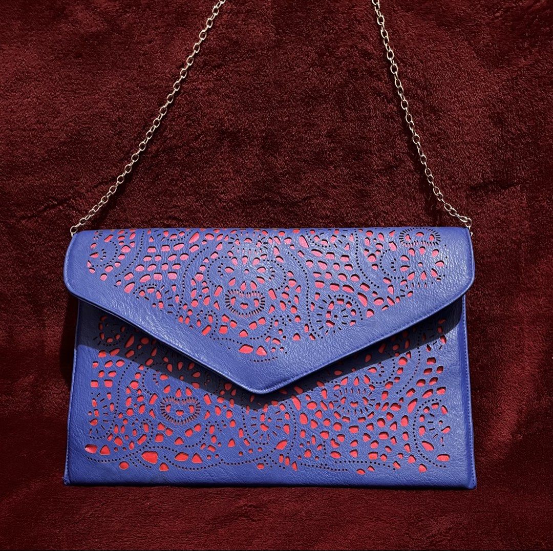 Blue Laser Cut Clutch Bag with Chain (Category: Clutches) located in La Trinidad. Submitted by whatnotcollections (Listing ID 1447811564, Image 1). Description: - Eye-catching blue laser-cut design with bold bright pink combination. - Detachable silver chain shoulder strap. - Secure magnetic snap closure - Ideal for evening wear and special occasions - Dimensions: Approximately 12.5 inches wide by 8.25 inches tall Slightly negotiable for sure buy