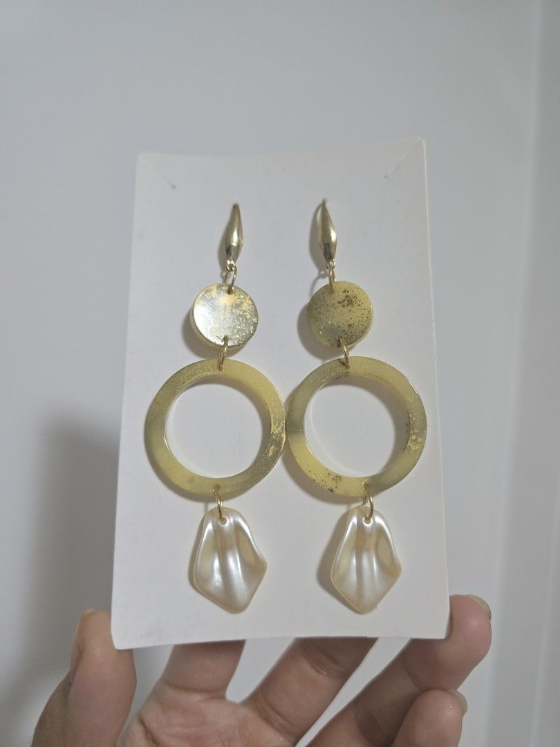 BUNDLE OF 2: Gold Tone Statement Earrings with Pearl Dangles (Category: Earrings) located in Pasig City. Submitted by callmemaf (Listing ID 1447681319, Image 2). Description: - Set of 2 unique gold tone earrings. - One pair features circular and pointed charms. - The other pair has half-circle charms with textured gold accents. - Both pairs have creamy, shell-shaped pearl dangles. - Ideal for dressing up any outfit. - gold plated ss316.