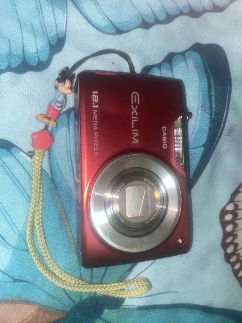 Casio EXILIM 12.1MP Digital Camera - Red (japan) (Category: Cameras) located in Capas. Submitted by jp.sor (Listing ID 1447857313, Image 2). Description: - Red Casio EXILIM digital camera - 12.1 megapixels - 4x optical zoom - Comes with a cute Mickey Mouse charm strap - Great for quick snaps and everyday use - Still in good working condition.