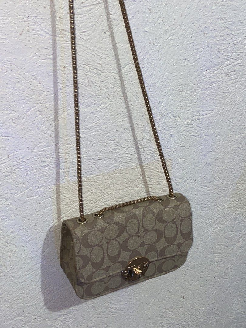 Coach Signature Canvas Chain Shoulder Bag (Category: Luxury Bags & Wallets) located in Lopez. Submitted by hariya00 (Listing ID 1447728798, Image 2). Description: - Coach mini shoulder bag in brown signature canvas - Gold-tone chain strap, eyelets, and front turn-lock style hardware - Flap closure with rounded rectangular shape - Dark fabric interior with open main compartment - Visible wear includes fading/discoloration on canvas, edge wear, and