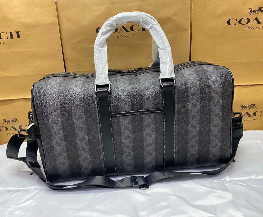 Coach Signature Striped Weekender Duffel Bag (Category: Shoulder Bags) located in Caloocan City. Submitted by brandeditemsph (Listing ID 1447853152, Image 3). Description: - Coach weekender duffel bag - Signature pattern with vertical stripes - Color: Black and grey - Spacious interior with zip closure - Features top handles and a detachable shoulder strap - Ideal for travel or gym use.