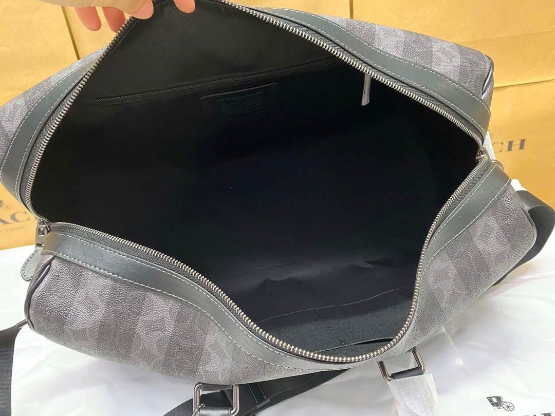 Coach Signature Striped Weekender Duffel Bag (Category: Shoulder Bags) located in Caloocan City. Submitted by brandeditemsph (Listing ID 1447853152, Image 2). Description: - Coach weekender duffel bag - Signature pattern with vertical stripes - Color: Black and grey - Spacious interior with zip closure - Features top handles and a detachable shoulder strap - Ideal for travel or gym use.