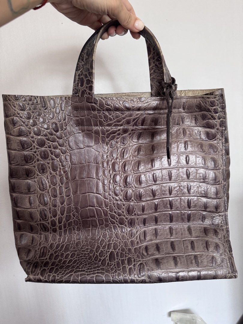Furla Crocodile Embossed Leather Tote Bag (Category: Luxury Bags & Wallets) located in Makati City. Submitted by curatedandnearlynew (Listing ID 1447765757, Image 1). Description: - Croc embossed leather tote bag. - Color: dark gray - Features a secure internal zippered compartment. - Lined with a distinctive purple fabric showcasing a repeating logo. - Includes a charming small leather tag with an 'F' initial. - Ideal for everyday use or travel 
