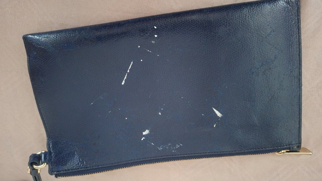 Furla Navy Leather Clutch Bag (Category: Luxury Bags & Wallets) located in Pasay City. Submitted by chaserstar (Listing ID 1447728830, Image 3). Description: Authentic Navy blue leather clutch from Furla. Zip closure with wrist strap. Some marks and scuffs on the exterior, shown in photos. Leather is slightly sticky due to storage. Interior is clean. Great for essentials and for repainting. Original is priced at around $150. Super steal!.