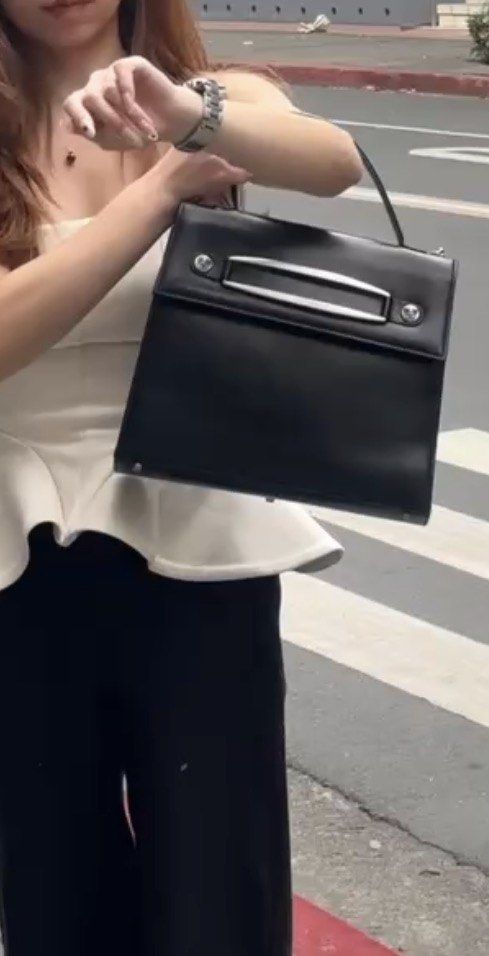 Gianni Versace Black Leather Top Handle Bag (Category: Luxury Bags & Wallets) located in Manila. Submitted by selling_everything_anything (Listing ID 1447805248, Image 2). Description: - Classic black leather handbag - Gianni Versace brand - Sleek design with silver hardware accents - Top handle for carrying - Interior features 'Gianni Versace Made in Italy' label - Timeless and stylish piece - Suitable for daily use or special occasions.