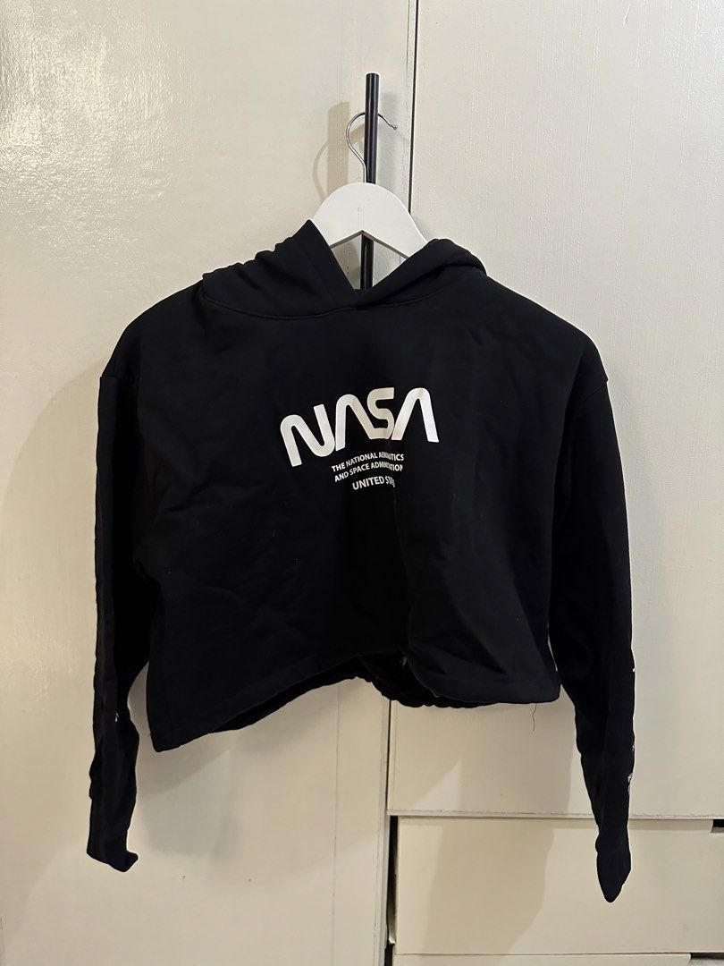 H&M Divided Black NASA Cropped Hoodie (Category: Coats, Jackets and Outerwear) located in Pasig City. Submitted by gwi0mi (Listing ID 1447873421, Image 1). Description: H&M Divided black cropped hoodie Size: Medium (M) Length: 18in Width: 21.5in Sleeve length: 30.5in • Features a NASA graphic on the front • Sleeve details include 'The National Aeronautics and Space Administration' • Graphic celebrates the Apollo 11 moon landing • Drawstring at th