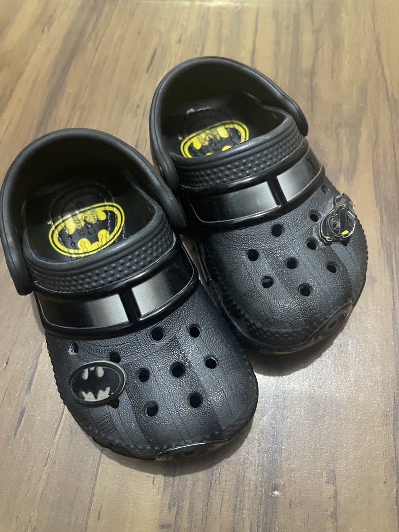 Kids' Black Batman Crocs with Jibbitz (Category: Babies & Kids Fashion) located in Manila. Submitted by jinsnow_ (Listing ID 1447741412, Image 1). Description: - Kids' Black Crocs with a cool Batman theme. - Features the Batman logo on the side and inside. - Includes a special Batman Jibbitz charm. - Stripes on the front for added style. - Perfect for young superhero fans. - Easy slip-on and slip-off design. Size: 5C.