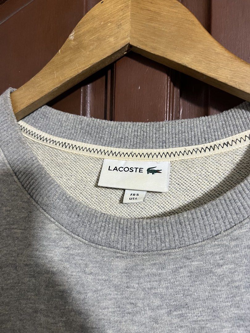 Lacoste Gray Embroidered Patch Design Pull Over Sweater (Category: Coats, Jackets and Outerwear) located in Manila. Submitted by thriftpoint99 (Listing ID 1447846198, Image 2). Description: 23x27 Issue stain fresh from bale. Not yet washed Good condition.