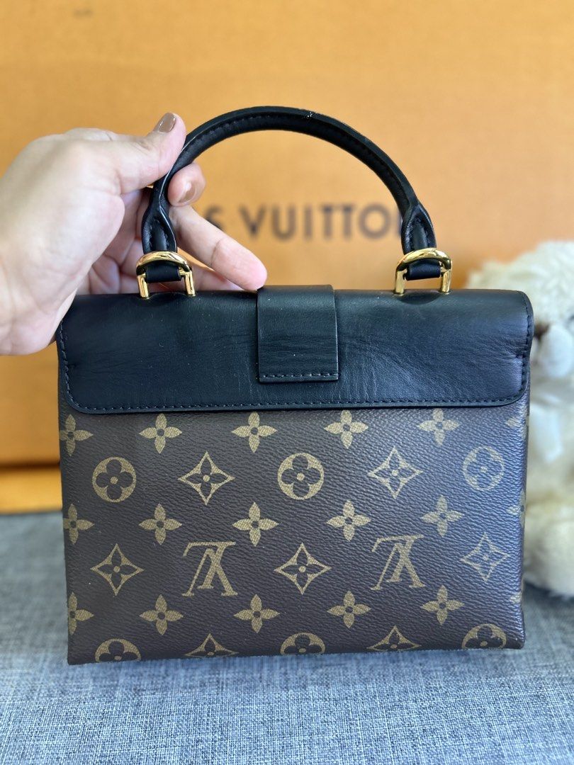 Louis Vuitton Monogram Lock Box Bag (Category: Luxury Bags & Wallets) located in Alicia. Submitted by berly06 (Listing ID 1447714093, Image 2). Description: - Classic Louis Vuitton monogram design - Stylish black leather top and gold lock closure - Spacious and dark interior - Functional top-handle bag for carrying essentials.