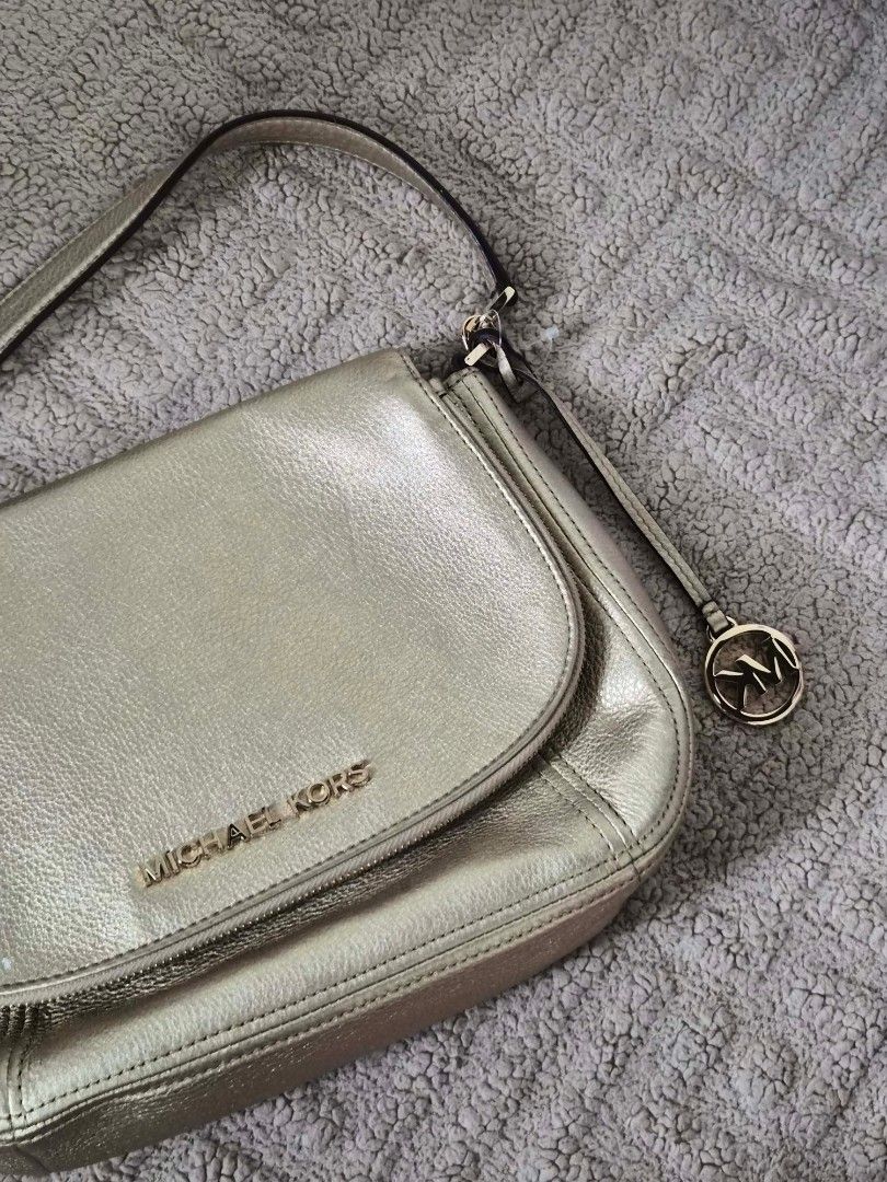 Michael Kors Metallic Gold Leather Shoulder Bag (Category: Luxury Bags & Wallets) located in Manila. Submitted by melvinchry47882 (Listing ID 1447703291, Image 1). Description: - Michael Kors shoulder bag - Metallic gold leather - Iconic MK logo charm - Interior MK logo lining - One interior zip pocket - Adjustable strap - Ideal for everyday wear.