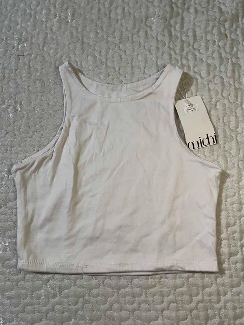 Michi White Ribbed Racerback Crop Tank Top (Category: Sleeveless) located in Manila. Submitted by luckybear.41559f (Listing ID 1447774706, Image 2). Description: - White ribbed crop tank top from Michi - Racerback style - Stretchy material - Versatile for layering or wearing alone - Comfortable and breathable fabric.