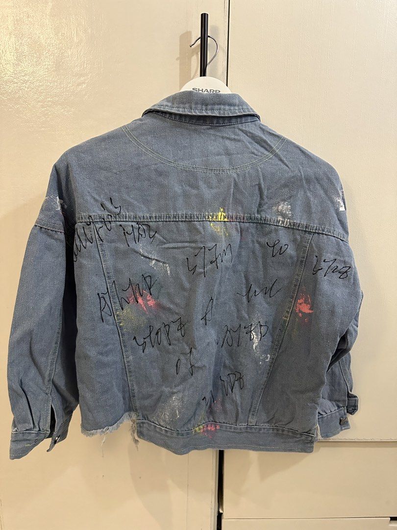 Mila Distressed Denim Jacket with Paint Splatter and Graffiti (Category: Coats, Jackets and Outerwear) located in Pasig City. Submitted by gwi0mi (Listing ID 1447874143, Image 2). Description: Brand: Mila Size: L Length: 22.9in Width: 22.5in Sleeve length: 28.5in Style: Denim Jacket Features: Distressed hem and cuffs Design: Colorful paint splatters all over Back Detail: Graffiti-style writing Condition: 10/10 No flaws Unique, great for layering.