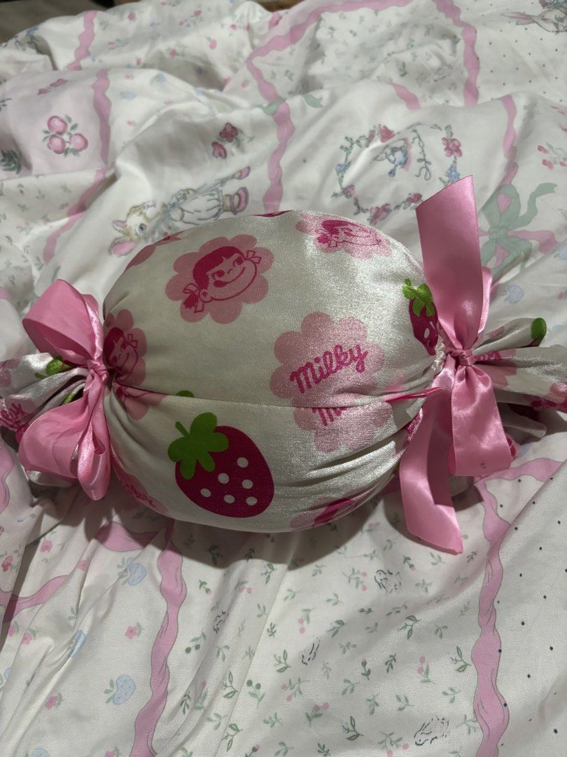 Milky Strawberry Candy Pillow (Category: Bedding & Towels) located in Manila. Submitted by meloopsy (Listing ID 1447809045, Image 1). Description: - Adorable Milky brand pillow - Candy shape with strawberry and character print - Soft pink satin ribbon ties at the ends - Super soft and squishy texture - Ideal for kawaii or cute room decor.