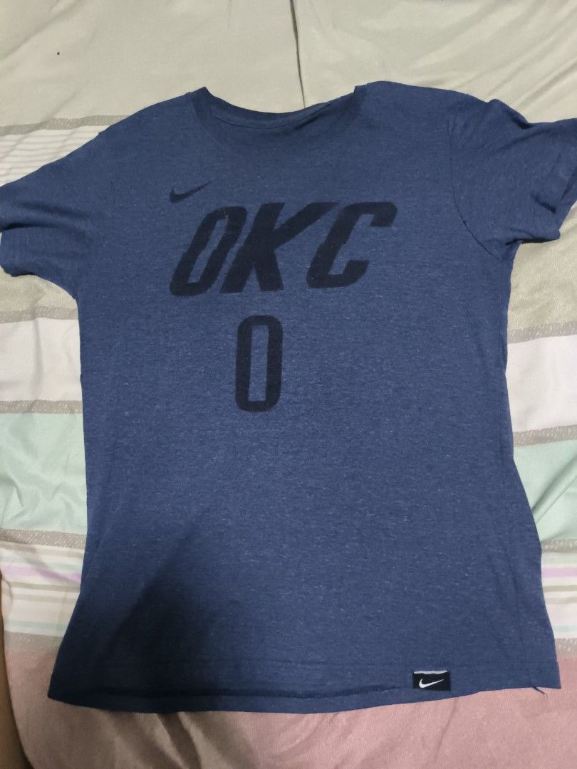 Nike OKC Thunder Russell Westbrook T-Shirt (Category: Tshirts & Polo Shirts ) located in Manila. Submitted by primo0925 (Listing ID 1447732421, Image 1). Description: - Blue Nike T-Shirt - Features OKC and the number 0 on the front - Resembles a Russell Westbrook jersey tee - Perfect for Oklahoma City Thunder fans - Made by Nike - Short sleeves, crew neck - Ideal for casual wear.
