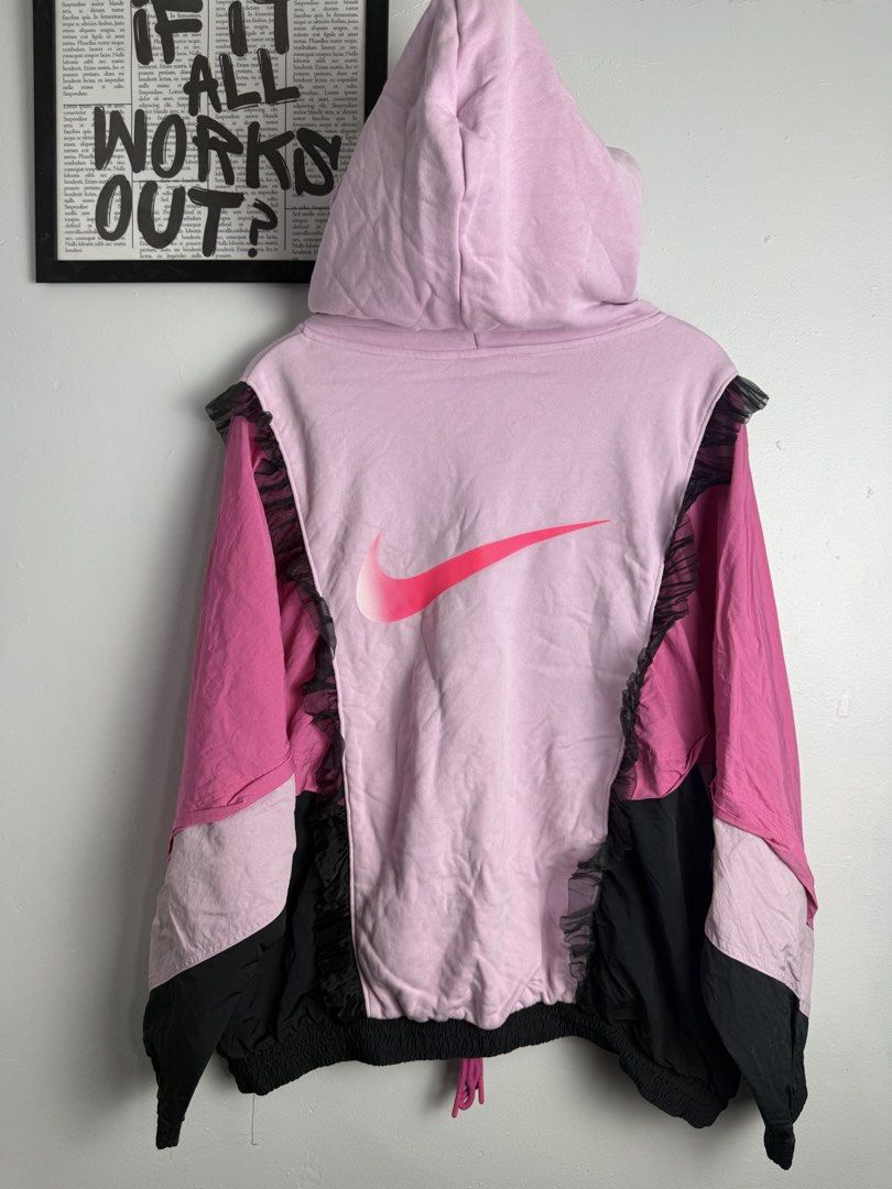 Nike Pink Black Hoodie (Category: Activewear) located in Manila. Submitted by wornagainstudios2 (Listing ID 1447691199, Image 2). Description: - Eye-catching Nike hoodie with pink and black color blocking. - Features unique sheer ruffle details on the sides and sleeves. - Adjustable drawstring hem for a customized fit. - Bold "big swoosh" logo prominently displayed on the back. - Perfect for creating a distinctive streetwear aesthetic. -perfect c