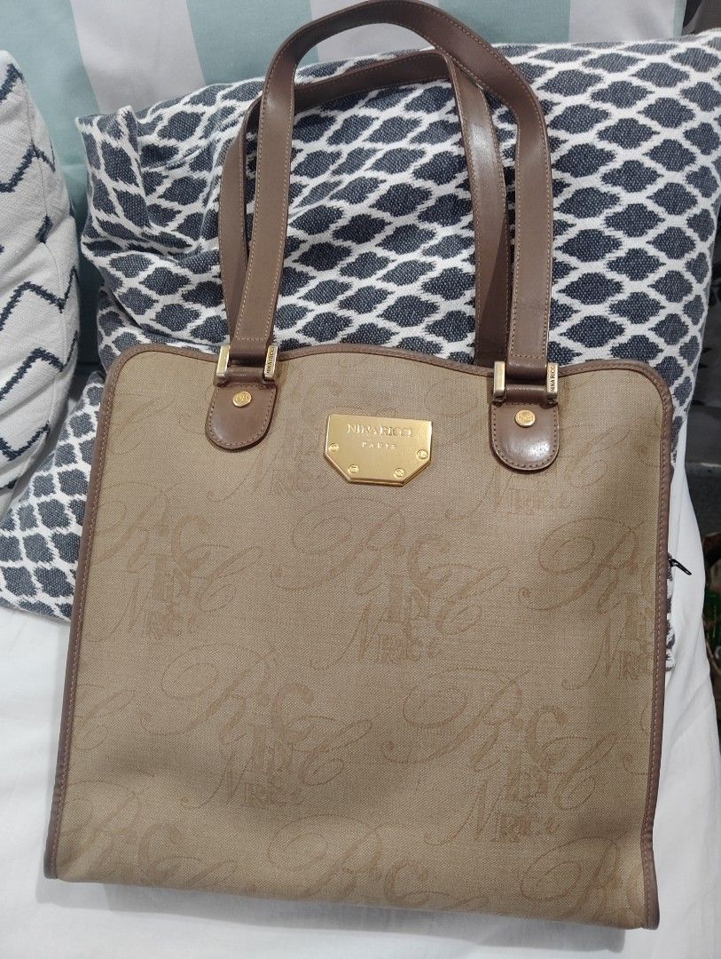 Nina Ricci Tote Bag Classic (Category: Shoulder Bags) located in Manila. Submitted by dcsago (Listing ID 1447727429, Image 1). Description: Brand: Nina Ricci Paris Style: Large shoulder tote Material: Beige coated canvas/jacquard with an all-over "NR" monogram pattern Trim: Brown leather or leather-look trim and shoulder straps Hardware: Gold-tone front plaque engraved "NINA RICCI PARIS" with NR-logo screws A vintage or early-2000s licensed Nina 
