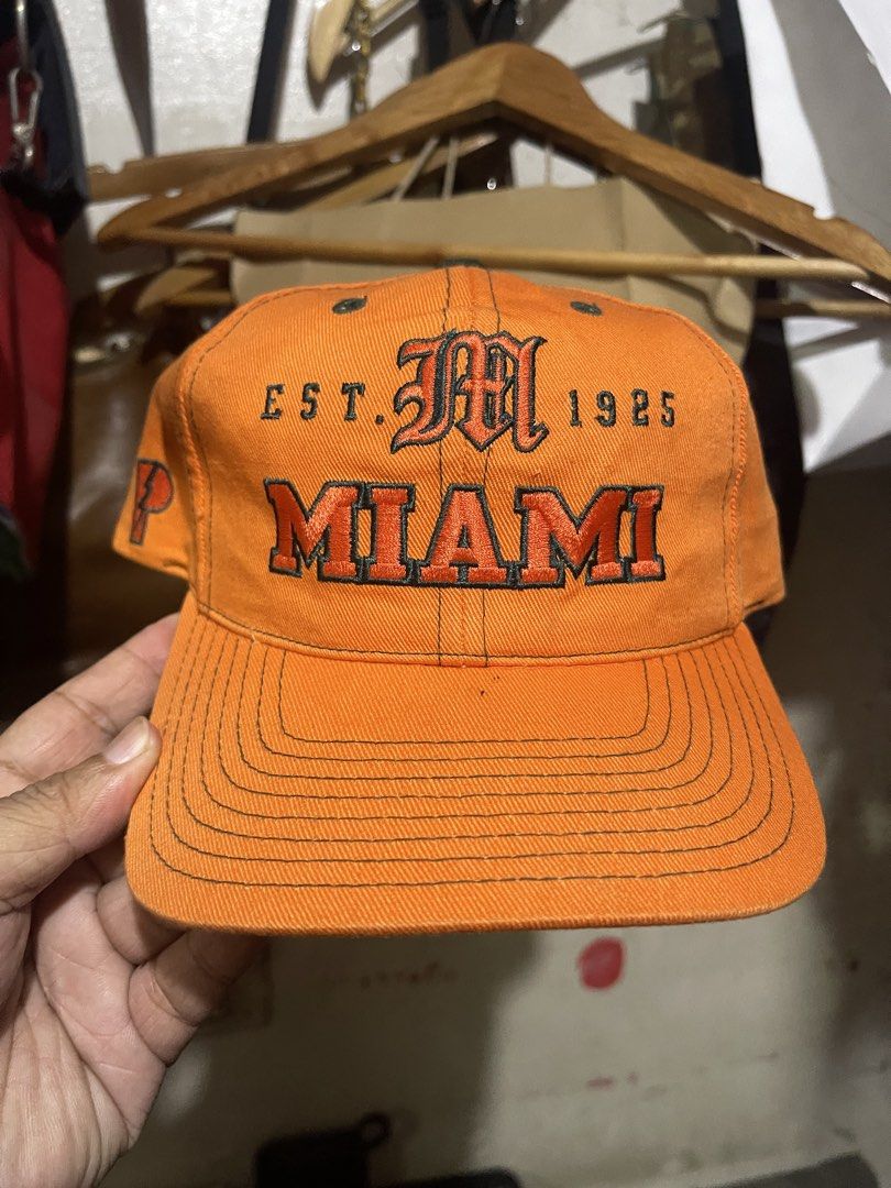 Orange Miami Est. 1925 Pro Player Snapback Cap (Category: Caps & Hats) located in Mandaluyong City. Submitted by mark2pac (Listing ID 1447842212, Image 1). Description: - Orange snapback cap - Embroidered 'Miami Est. 1925' on front - Lightning bolt 'P' logo on side - Pro Player brand tag inside - Adjustable snap closure at back - Perfect for Miami fans.