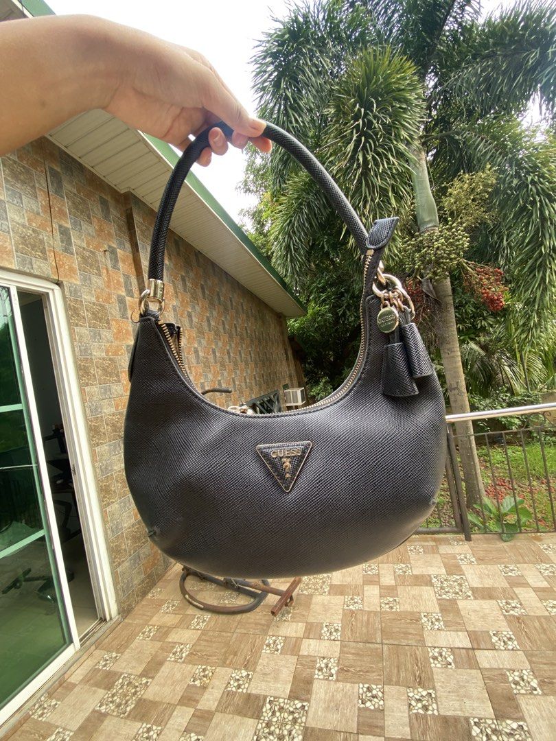 ORIGINAL Guess Black Textured Hobo Shoulder Bag (Category: Shoulder Bags) located in Mariveles. Submitted by preluvbaddie (Listing ID 1447697584, Image 2). Description: ORIGINAL BOUGHT IT AT TRINOMA GUESS FOR 9k - Black Guess hobo bag - Textured material - Gold tone hardware with tassel detail - Zipper closure - Shoulder strap and top handle - Ideal for everyday use.