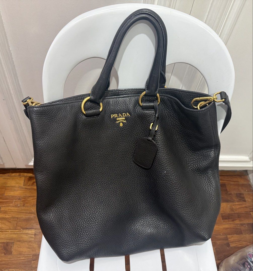 Prada Black Leather Tote Bag with Gold Hardware scratch proof (Category: Luxury Bags & Wallets) located in Quezon City. Submitted by olxph_441031685 (Listing ID 1447713930, Image 3). Description: - Authentic Prada Black Leather Tote Bag - Pebbled leather exterior - Gold-tone hardware - Spacious interior with multiple compartments - Interior zippered pocket - Top handles - Detachable shoulder strap - Classic Prada logo on front - Versatile for dai