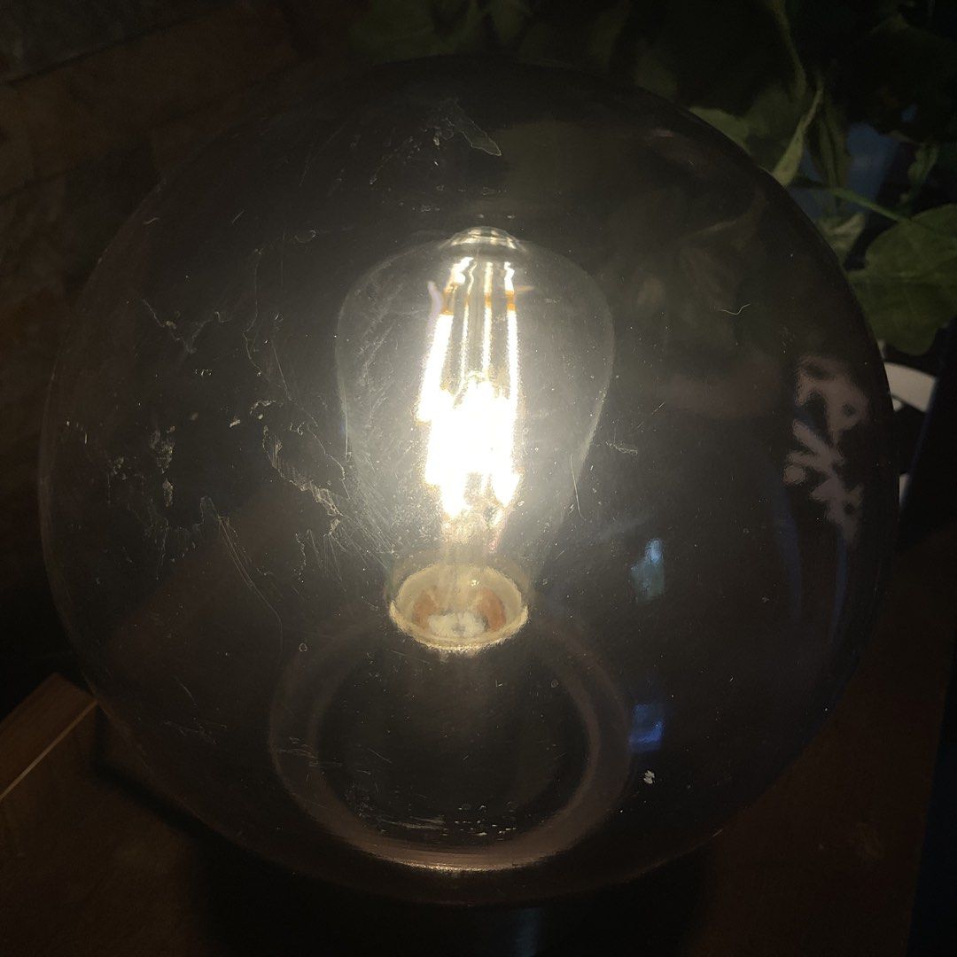 Smoke Globe Table Lamp with Edison Bulb (Category: Lighting) located in Marilao. Submitted by thewoodstudio (Listing ID 1447720681, Image 3). Description: Glass globe lamp with brushed metal base. Comes with an Edison-style bulb. *The black tinted coating is started peeling off. .