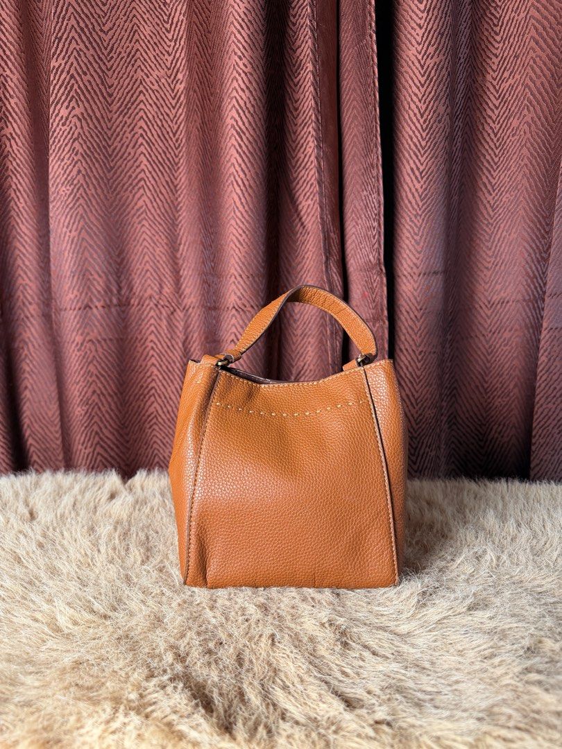Tory Burch Brown Leather Bucket Bag (Category: Luxury Bags & Wallets) located in Manila. Submitted by femnlofficial (Listing ID 1447881198, Image 3). Description: - Authentic Tory Burch brown leather bucket bag - Textured leather with signature embossed logo - Features top handles - Simple and classic design - Ideal for everyday use - Spacious enough for your essentials.