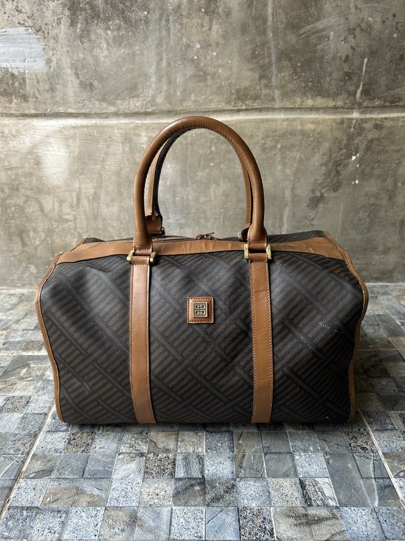 Vintage Givenchy Monogram Canvas Leather Trim Duffle Bag (Category: Luxury Bags & Wallets) located in Quezon City. Submitted by commonwealthpickerph (Listing ID 1447688459, Image 1). Description: Vintage Givenchy Monogram Canvas Leather Trim Duffle Bag - 13.5 width // 8 height // 8.5 length - Iconic monogram print - Brown leather trim and handles - Gold hardware details - Ideal for weekend trips or stylish carry-on - Shows some signs of wear on l