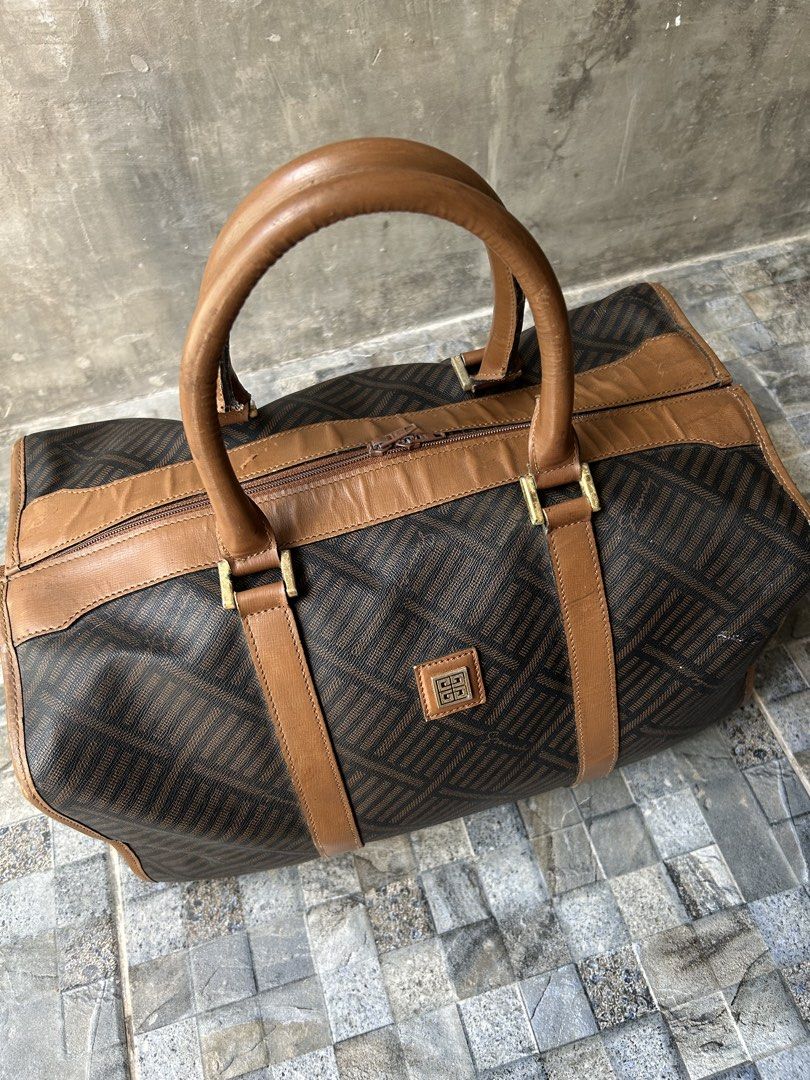 Vintage Givenchy Monogram Canvas Leather Trim Duffle Bag (Category: Luxury Bags & Wallets) located in Quezon City. Submitted by commonwealthpickerph (Listing ID 1447688459, Image 2). Description: Vintage Givenchy Monogram Canvas Leather Trim Duffle Bag - 13.5 width // 8 height // 8.5 length - Iconic monogram print - Brown leather trim and handles - Gold hardware details - Ideal for weekend trips or stylish carry-on - Shows some signs of wear on l