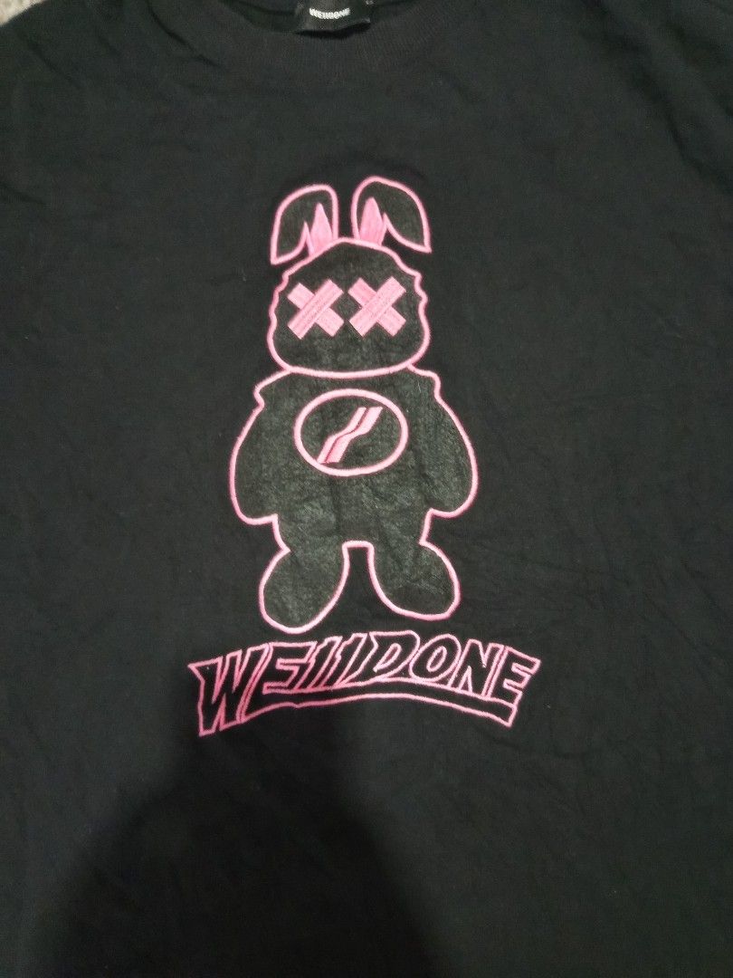WE11DONE Black Graphic T-Shirt Bunny Logo (Category: Tshirts & Polo Shirts ) located in Ligao. Submitted by john_thrift (Listing ID 1447719082, Image 2). Description: - Black WE11DONE t-shirt -Dime: 19 x 29 - Features a cute pink bunny graphic - 'WE11DONE' text printed below the graphic issue: Cut wash tags 350 shipped.