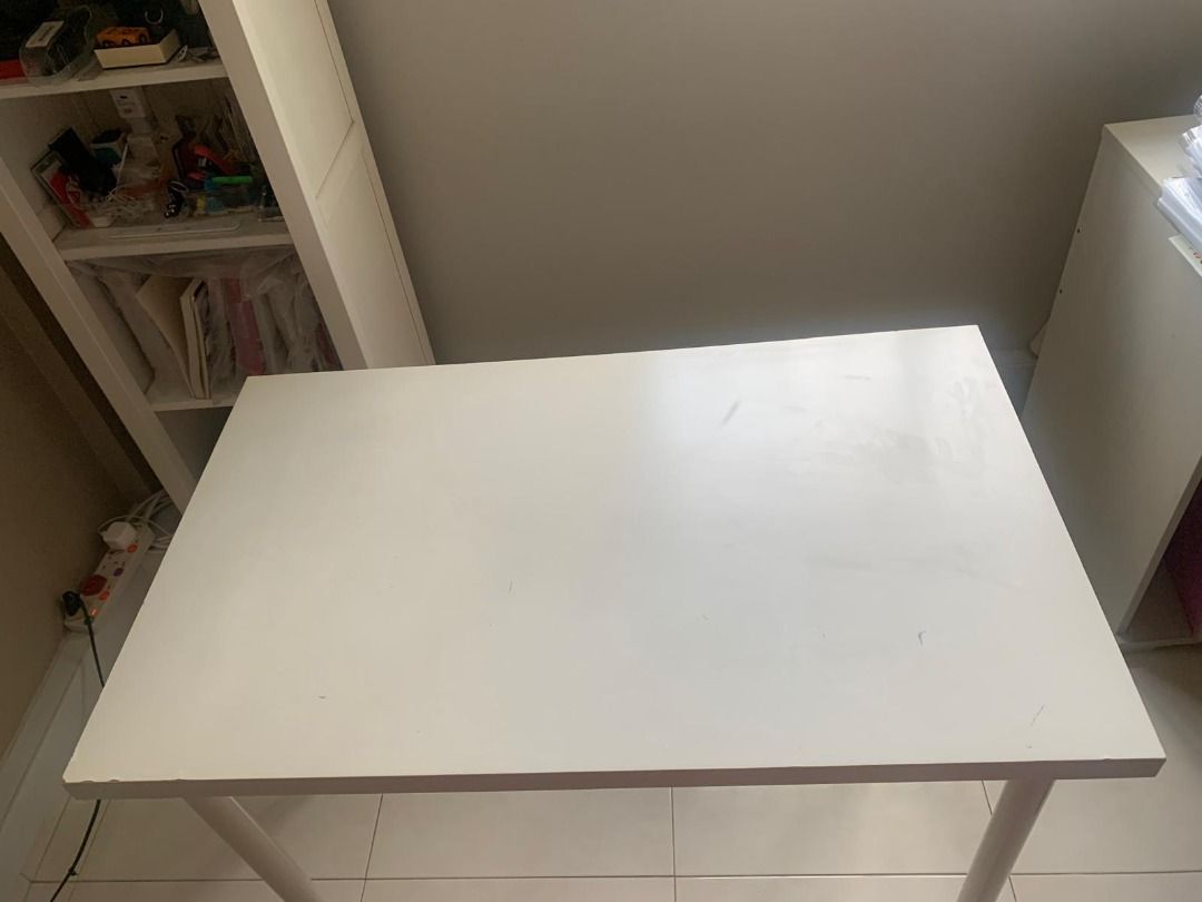 White Study Table (Category: Tables & Sets) located in Singapore. Submitted by bluepea7 (Listing ID 1447688982, Image 2). Description: - Dimension: W 100cm x D 60 cm x H 74cm - Simple white study table - Ideal for small workspaces or as a side table - Sturdy white metal legs - Surface has minor marks from use - Functional and easy to clean - Great for students or home office setups.