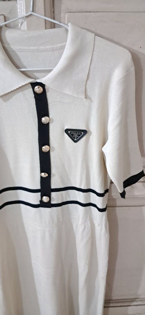 White Top with Black Trim and Buttons (Category: Sleeveless) located in Manila. Submitted by abundantjoy.76 (Listing ID 1447841518, Image 3). Description: - Chic white top with elegant black trim details. - Features a classic collar and a button-up front. - Adorned with beautiful pearl-like buttons. - Subtle triangular logo embroidered on the chest. - Perfect for both casual and dressed-up looks. NEW! NEVER USED .