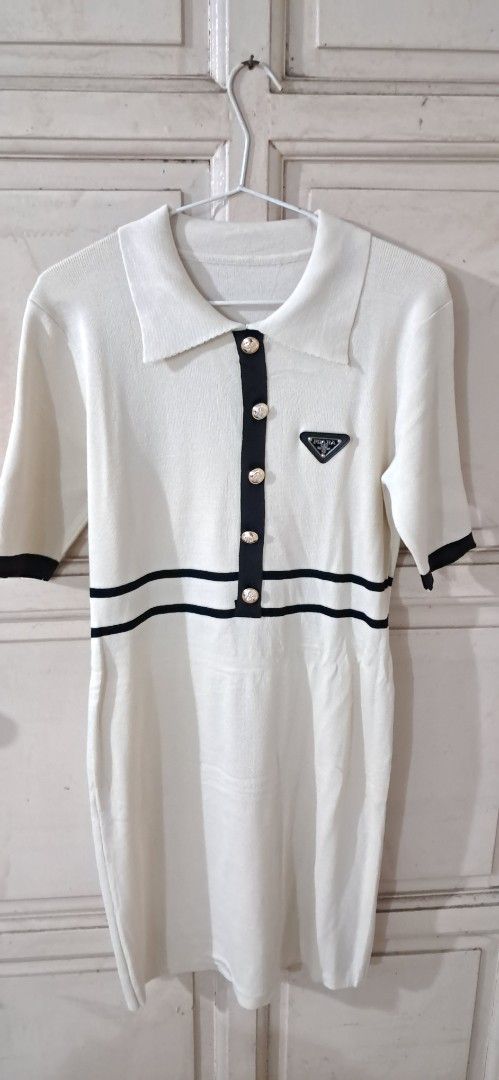 White Top with Black Trim and Buttons (Category: Sleeveless) located in Manila. Submitted by abundantjoy.76 (Listing ID 1447841518, Image 2). Description: - Chic white top with elegant black trim details. - Features a classic collar and a button-up front. - Adorned with beautiful pearl-like buttons. - Subtle triangular logo embroidered on the chest. - Perfect for both casual and dressed-up looks. NEW! NEVER USED .