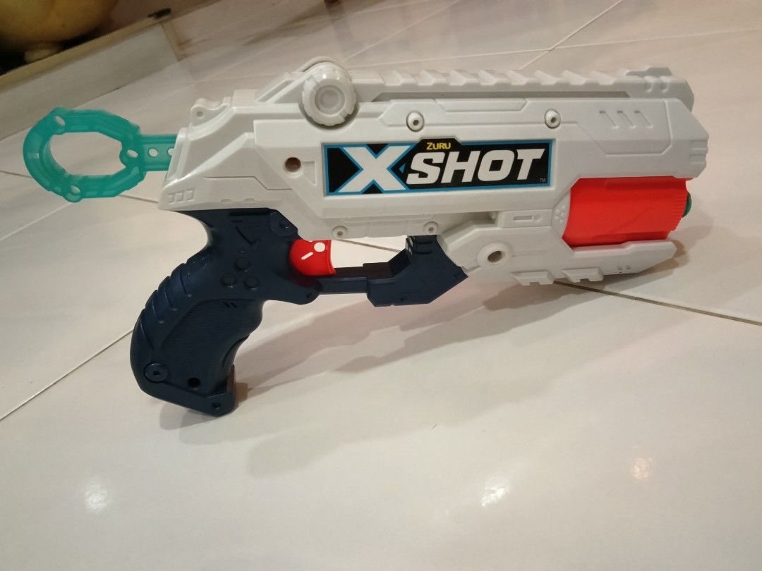 X-Shot ZURU Toy Dart Blaster Gun (Category: Toys & Games) located in Puchong. Submitted by jieling11 (Listing ID 1447830750, Image 2). Description: - X-Shot ZURU toy dart blaster - Colour: White, blue, and orange accents - Features a pull-back mechanism for firing - Includes a ring on the handle - Perfect for kids' playtime and action-packed fun.