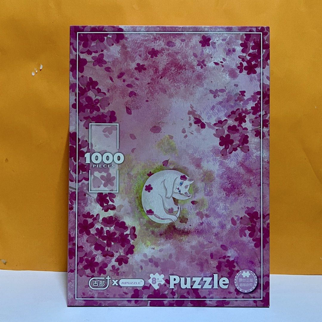1000 Piece Jigsaw Puzzle - Cat & Cherry Blossoms (Category: Art & Prints) located in Imus. Submitted by vansteph_080923 (Listing ID 1447954994, Image 1). Description: - 1000 piece jigsaw puzzle - Adorable sleeping cat design surrounded by cherry blossoms - Pink and floral themed box and pieces - Ideal for a relaxing and calming activity - Completed puzzle size: 530mm x 750mm - Comes with a poster guide for assistance - Has a few missing/damaged p