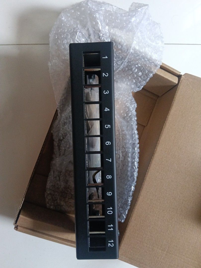 12-Port Network Patch Panel (Category: Networking) located in Singapore. Submitted by neighbourhoodelectrician (Listing ID 1447912607, Image 2). Description: - 12-port patch panel - Black casing with numbered ports 1-12 - Includes bubble wrap - Ideal for organizing network cables - Ready for pickup.