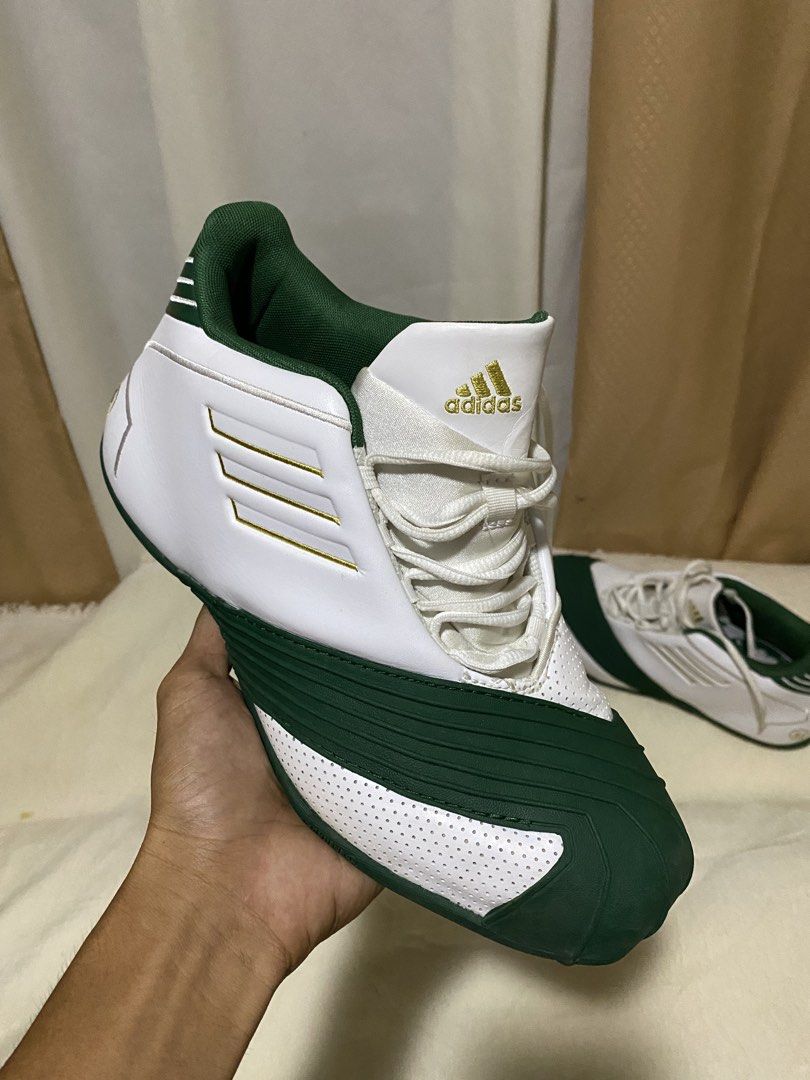Adidas T-Mac 1" x lebron james (Category: Sneakers) located in Barobo. Submitted by sonogonggr22560 (Listing ID 1448030440, Image 2). Description: - Adidas T-Mac 3 basketball shoes - Color: White with green and gold accents - Iconic three stripes design - '23' detail on the heel - Perfect for collectors or players.