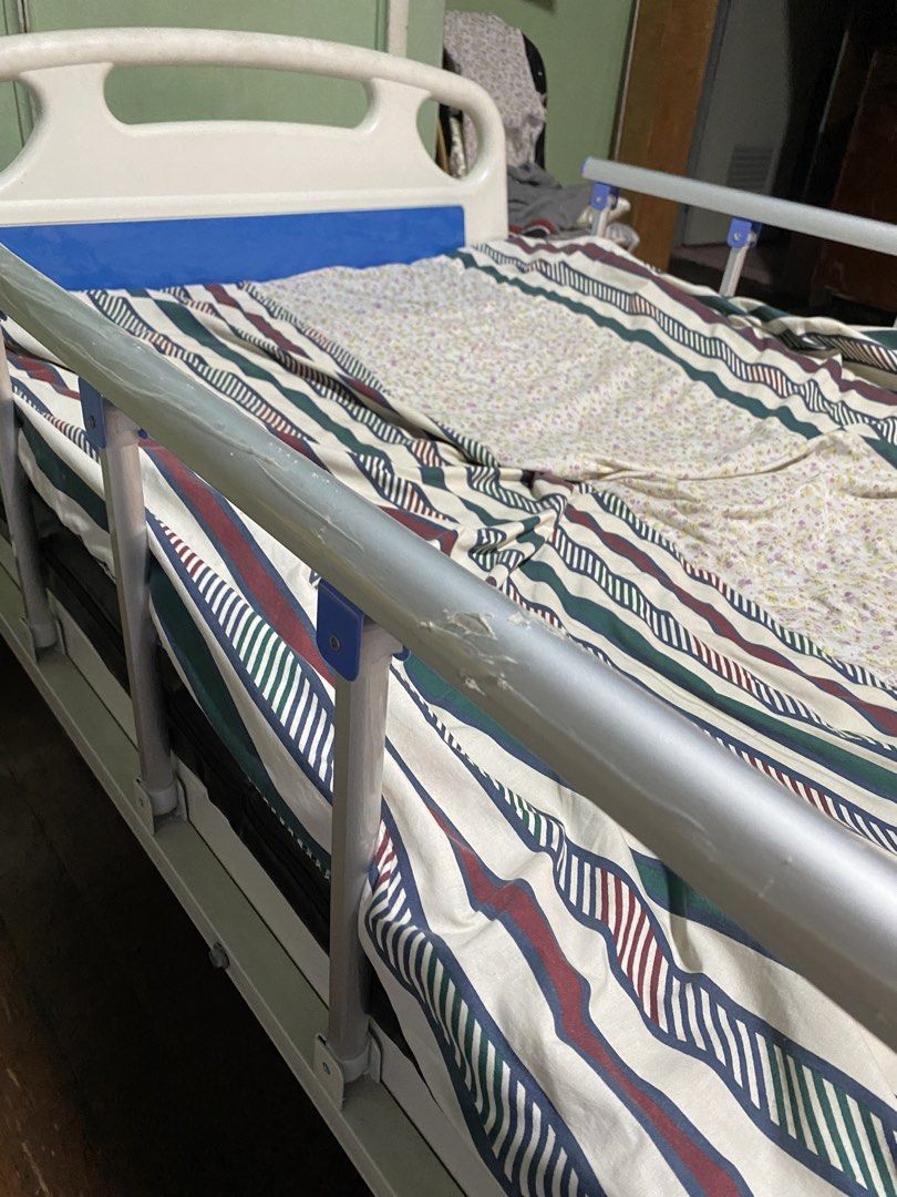 Adjustable Hospital Bed with Side Rails and Wheels (Category: Medical Supplies & Tools) located in Manila. Submitted by tavorafrancis8096 (Listing ID 1447907081, Image 3). Description: - Hospital bed for sale - Adjustable side rails - Wheels for easy movement - White and blue bed frame - Includes mattress and bedding - Perfect for home care needs.