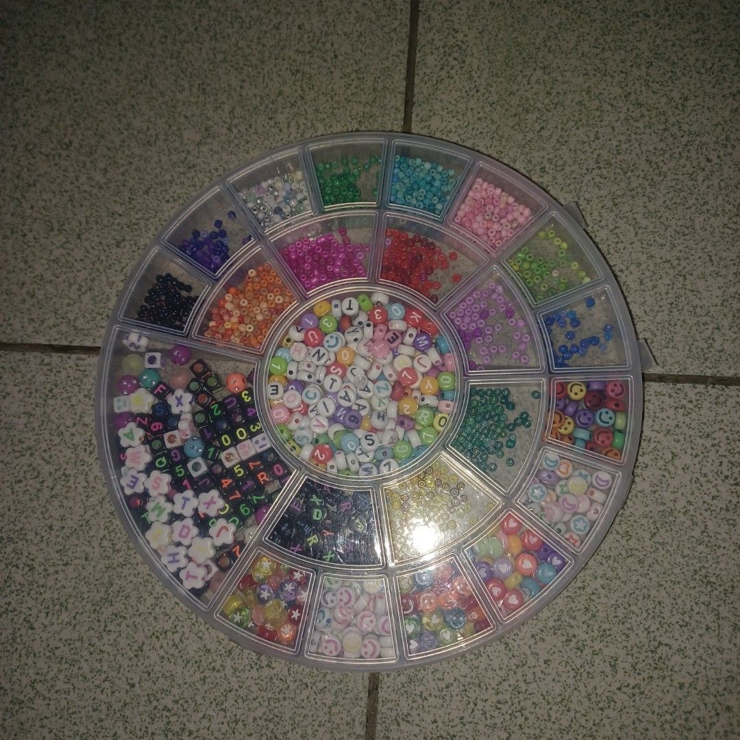 Assorted Craft Beads for Jewelry Making (Category: Craft Supplies & Tools) located in Quezon City. Submitted by ukaykingdom (Listing ID 1447935628, Image 1). Description: Assorted beads - Round plastic container filled with assorted craft beads. - Includes alphabet beads, smiley face beads, and flower beads. - Also contains a variety of colorful small beads. - Ideal for creating DIY bracelets, necklaces, and other jewelry. - Offers a great variet