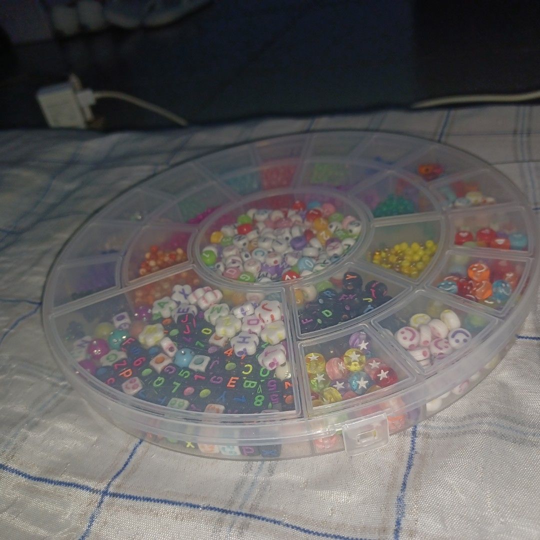 Assorted Craft Beads for Jewelry Making (Category: Craft Supplies & Tools) located in Quezon City. Submitted by ukaykingdom (Listing ID 1447935628, Image 2). Description: Assorted beads - Round plastic container filled with assorted craft beads. - Includes alphabet beads, smiley face beads, and flower beads. - Also contains a variety of colorful small beads. - Ideal for creating DIY bracelets, necklaces, and other jewelry. - Offers a great variet
